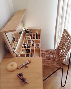 a wooden table topped with a mirror next to a drawer filled with bottles and other items