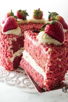 there is a piece of cake with strawberries on the top and one slice missing