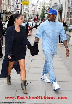 a man and woman walking down the street holding hands