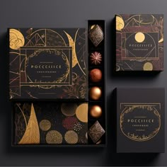 an assortment of chocolates in boxes on top of a black surface with gold foiling