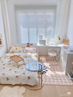 a small bedroom with a bed, desk and computer on the table in front of the window