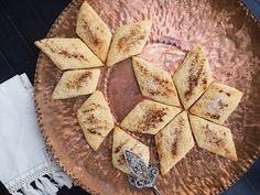 some food is on a metal plate with a spoon and napkins next to it