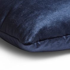 a blue velvet pillow on a white background