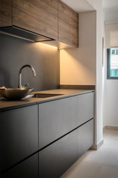 a modern kitchen with stainless steel sink and countertop, along with wooden cabinetry