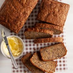 slices of banana bread and butter on a checkered tablecloth with a knife next to it