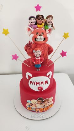 a three tiered red cake with cartoon characters on top