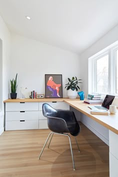 a chair sitting in front of a desk next to a window