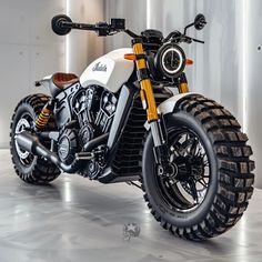 a white and black motorcycle is parked in a room with some metal pipes on the wall