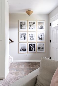 a living room with pictures on the wall and a couch in front of an open door