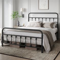 a black metal bed frame in a white bedroom