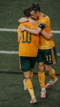 two soccer players hugging each other on the field