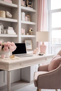 a white desk topped with a laptop computer sitting next to a pink flower filled vase