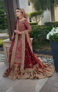 a woman in a red and gold bridal gown