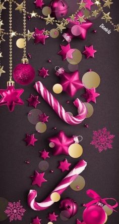 pink and gold christmas decorations on a black background with snowflakes, balls, stars and candy canes