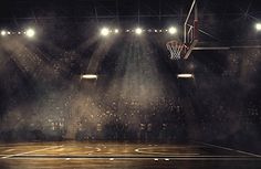 an empty basketball court with spotlights on it