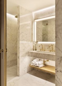 a bathroom with marble counter tops and gold faucets