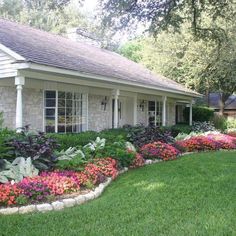 a house with flowers in the front yard