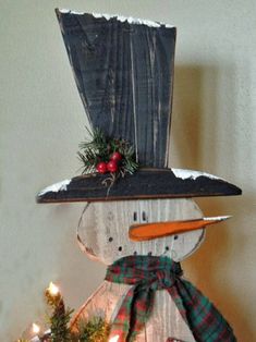 a wooden snowman with a hat and scarf on top of it's head