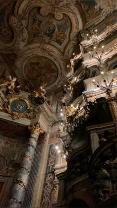 an ornately decorated room with chandeliers and paintings on the ceiling is shown