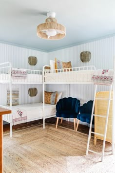 a bedroom with bunk beds, chairs and rugs on the floor in front of them