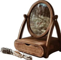 a small wooden vanity with a mirror on it's stand and a key chain