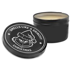 a candle in a black tin with the words smells like a grumpy christmas on it