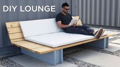 a man sitting on a bench reading a book with the words diy lounge in front of him