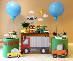 a table topped with balloons and toys on top of a tiled floor next to a wall