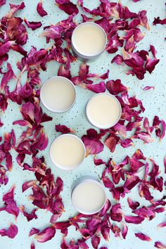 three cups filled with milk surrounded by petals