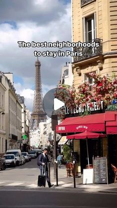 a man walking down the street with his luggage in front of the eiffel tower