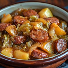 a bowl filled with sausage and potatoes on top of a table