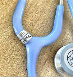 a blue stethoscope laying on the floor next to a small clock and pen