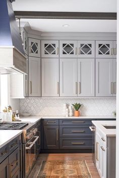 a kitchen with gray cabinets and white counter tops is seen from the doorway to the dining room