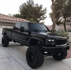 a black truck parked in front of a house