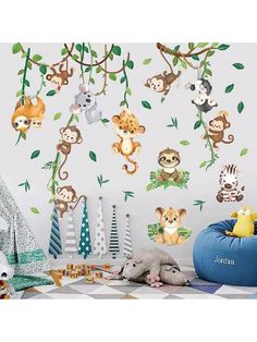 monkeys and giraffes are hanging on the tree branch wall decals in this children's room