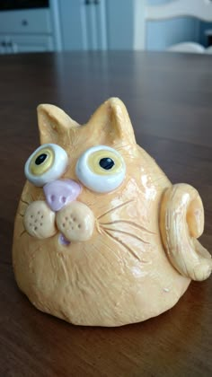 a cat figurine sitting on top of a wooden table