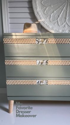 a gray dresser with rope handles and drawers