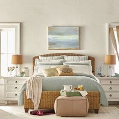 a bedroom with wicker furniture and paintings on the wall, along with white walls