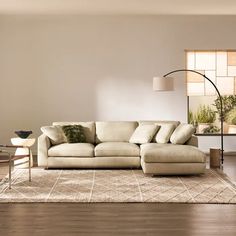 a living room filled with furniture and a large rug on top of a hard wood floor