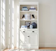 a white bookcase with books on top of it