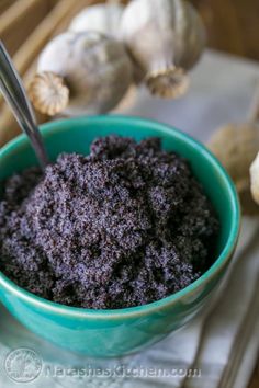 a blue bowl filled with poppy seed fillers and a spoon in the bowl next to it