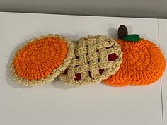 two crocheted pumpkins sitting next to each other