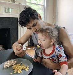 a man and child eating food at a table