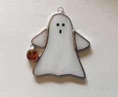 a white ghost ornament with a jack - o - lantern hanging from it's side