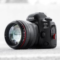 a canon camera sitting on the ground with its lens up