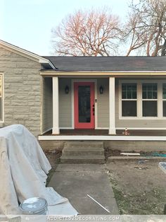 a house that has been painted gray with red door and window trim on the front