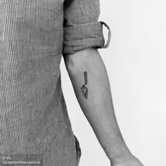 black and white photo of a man's arm with a knife tattoo on it