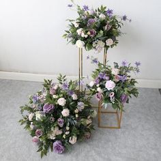 two gold plant stands with flowers on them