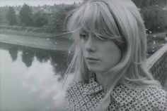 a black and white photo of a woman with blonde hair looking off into the distance