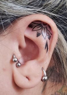 a close up of a person's ear with tattoos on it